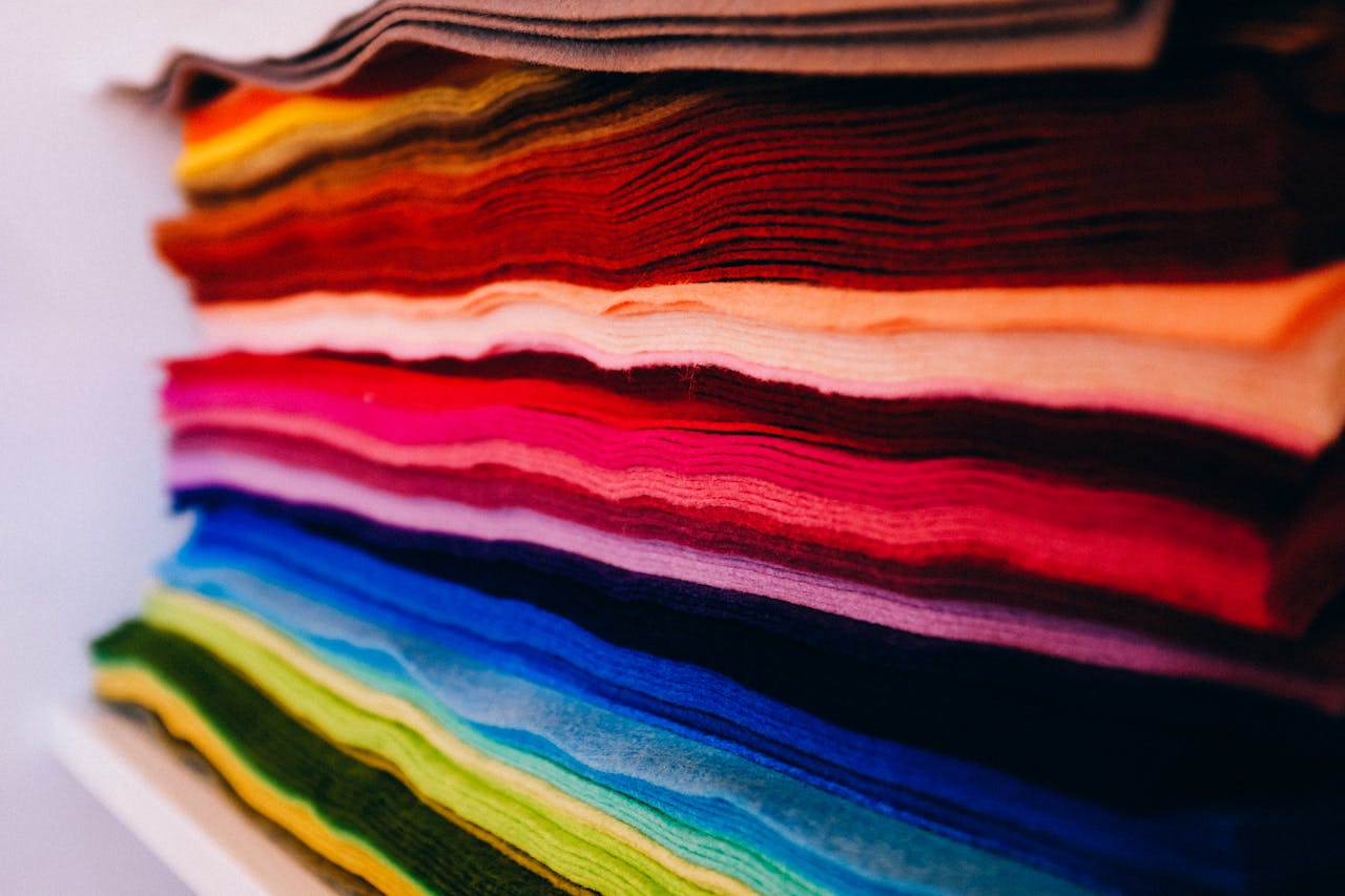 A vivid and artistic close-up of neatly stacked multicolored textiles indoors.